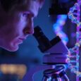 Forskare undersöker DNA med mikroskop i ett blåviolett laboratorium